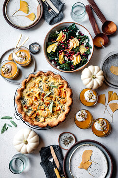 Fall holiday meal with quiche and sald and pumpkins