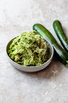 Shredded zucchini ingredient on a marble background with copy space