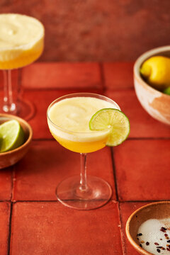 Pineapple Lime Margarita on terracotta tile surface with chilli salted rim