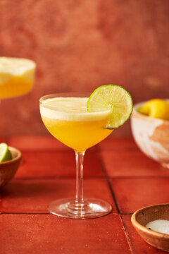 Pineapple Lime Margarita on terracotta tile surface with chilli salted rim