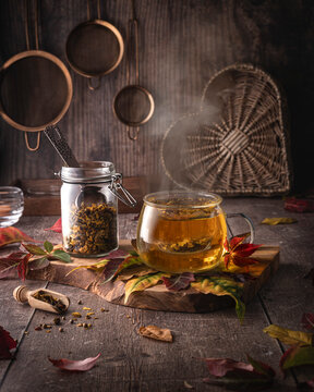 Pumpkin Spice Tea in a clear glass mug, with fresh tea stored in a glass jar, in a rustic kitchen