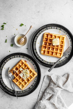 Waffles topped with garlic and herb cream cheese and honey