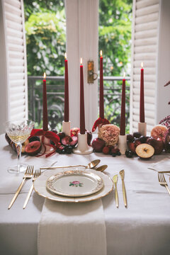 Close caption of a festive table setting with candles, fruits and flowers