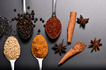 Horizontal group of spices, sesame, pepper, turmeric, cayenne peper