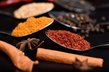 Horizontal group of spices, sesame, pepper, turmeric, cayenne peper