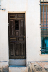 Ancient Wooden Door in a Weathered White Wall in Barcelona, Spain