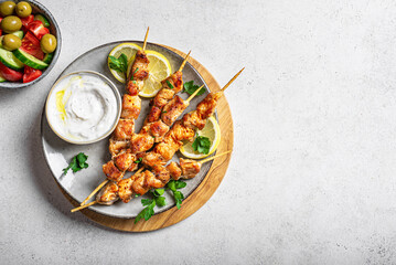 Chicken kebabs, skewers with yogurt sauce and  fresh vegetable salad