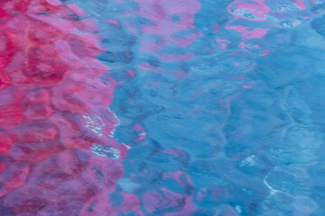 Colorful abstract pattern in blue and pink tones, resembling reflections on water or textured glass. Ideal for backgrounds, design, and artistic use