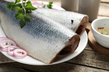 Tasty herring fillets with spices on wooden table, closeup