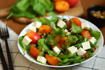 Salad with arugula and apricot in a white plate