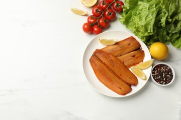 Delicious smoked herring fillets with lemon slices and other products on white table, flat lay....
