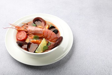Tasty seafood soup in bowl on light grey table, closeup. Space for text