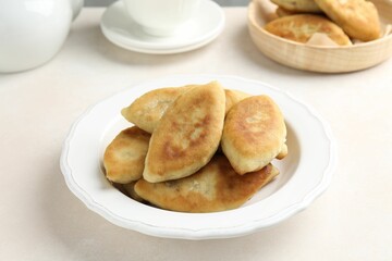Delicious fried pyrizhky (stuffed pies) on white table, closeup