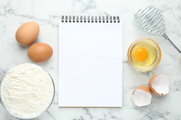 Blank recipe book, whisk, flour and eggs on white marble table, top view. Mockup for design