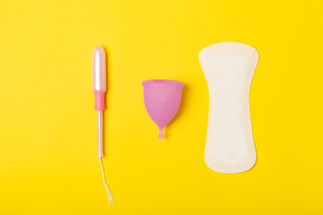 Menstrual cup on a bright background. Sanitary napkins, tampons and menstrual cup.Concept of critical days, menstruation.feminine hygiene product. Women health concept.Premenstrual syndrome.Copy space