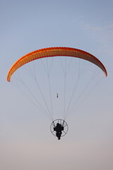 Paramotor Pilot Soaring Through the Clear Blue Sky