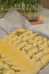 Twisted dough strips with a brush. Microgreens sprouts on kitchen table. Home cooking baking puffs