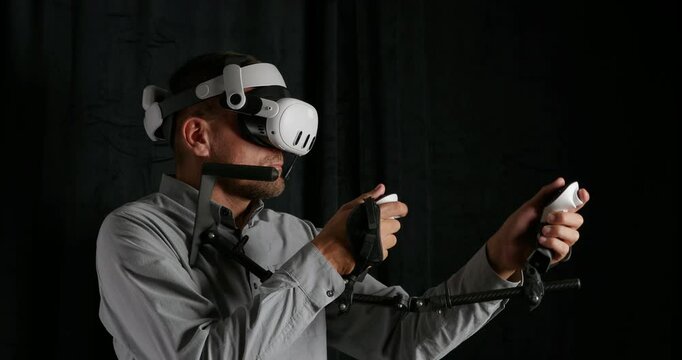 Man playing in VR, controllers attached to virtual reality gun-stock.