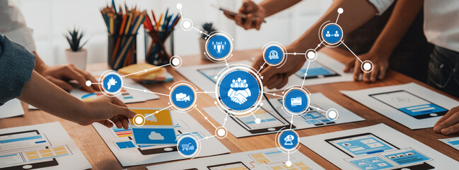 A vibrant scene showcasing a collaborative business strategy session with diverse individuals interacting over digital tools and graphics on a creative workspace. Amity
