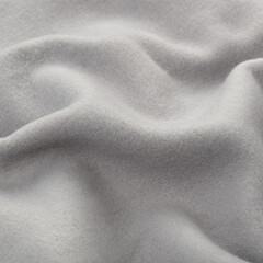 Fototapeta premium Fleece fabric texture with wave gray color. Crumpled fabric grey background. Textile luxury textured macro close-up studio shot above at angle