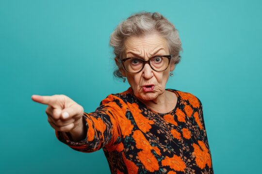 Furious elderly woman pointing in anger