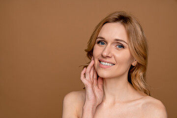 Woman with beautiful face touching healthy facial clean skin. Attractive smiling middle age model...