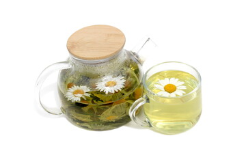 On a white background there is a glass teapot and a glass with chamomile infusion.
