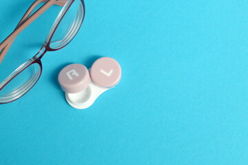 On a blue background there are glasses with containers for lenses.	