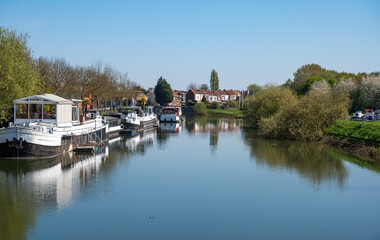 Boats and houses reflecting in the water of the river Lys or Leie in Menen, West Flanders, Belgium