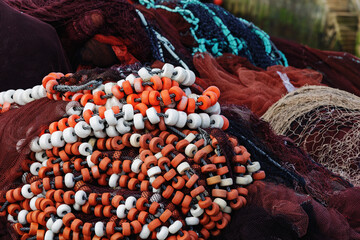 Fishing nets with colorful floats stacked in a seaport