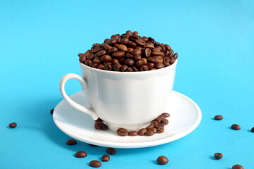 A cup with coffee beans stands on a blue background.	