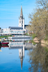 Naklejka premium View over the village and Saint Medardus church reflecting in the river Lys or Leie in Wervik, West Flanders, Belgium