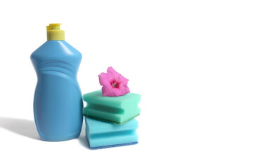 On a white background there is a blue bottle with detergent and sponges for washing dishes.	