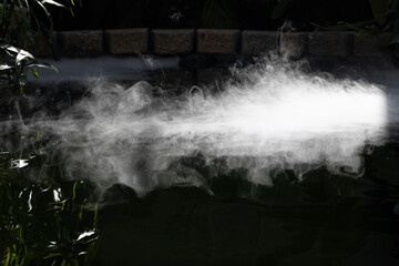 fog rolling across water on dark background