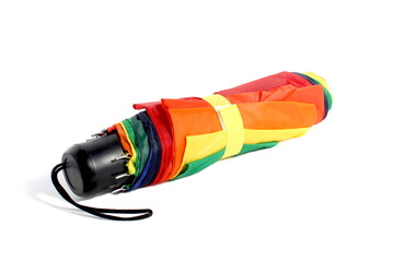 A closed umbrella lies on a white isolated background.
