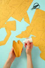Paper folding and gluing technique: hands engaged in precision craft project
