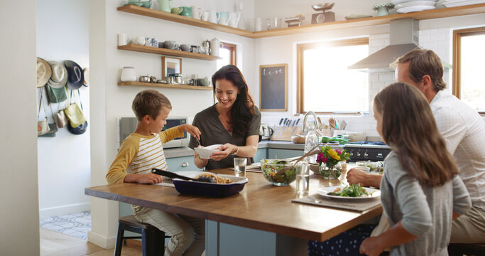 Smile, lunch and serving with family at kitchen table for help, bonding and health salad. Food, support and happiness with parents and children eating at home for love, wellness and relax together - Powered by Adobe