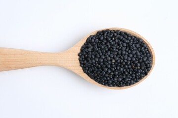 Raw lentils in wooden spoon isolated on white, top view