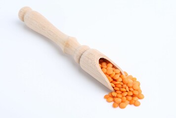 Raw lentils in wooden scoop isolated on white