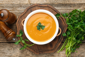 Delicious lentil cream soup with parsley on wooden table, top view