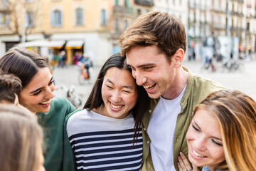 Fototapeta premium Young group of happy people enjoying time together at city street. Millennial generation friends having fun, laughing while enjoying holiday trip. Friendship and youth concept