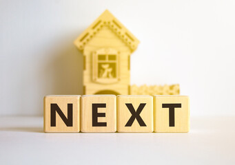 Next symbol. Concept word Next on beautiful wooden blocks. Beautiful white table white background. Wooden beautiful house. Business, lifestyle, support and next concept. Copy space.