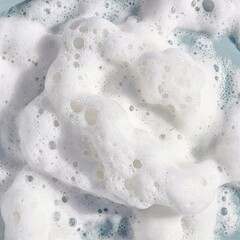 Close-up of lush white foam with lots of small and large bubbles on a light surface. Light and airy texture.