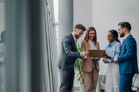 Business people reading documents together in office
