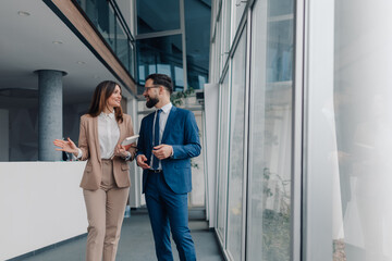 Businesspeople walking and talking in modern office building