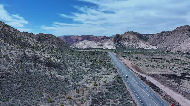 Aerial desert highway red white sandstone volcanic mountains Utah. Southwestern desert. Volcano cinder cone mountains in desert landscape. Geological landscape wind, weather and water carved erosion.