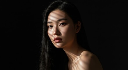 Fototapeta premium Dramatic portrait of woman with light and shadow play for artistic design