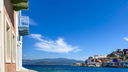 Colorful Waterfront Houses And Mosque In Kastellorizo, Greece, Seen From A Coastal Walk On A Clear...