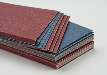 Stack of red and blue sandpaper sheets, arranged in alternating colors.