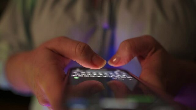 Person interacting with smartphone displaying bright green screen, tapping the top-right corner in softly lit indoor room, ideal for UI UX mockup, mobile interface presentation, chroma key editing